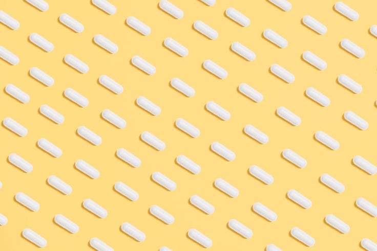a lot of pills spilled on a yellow background