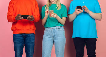 young people in colourful t-shirts using mobile phones