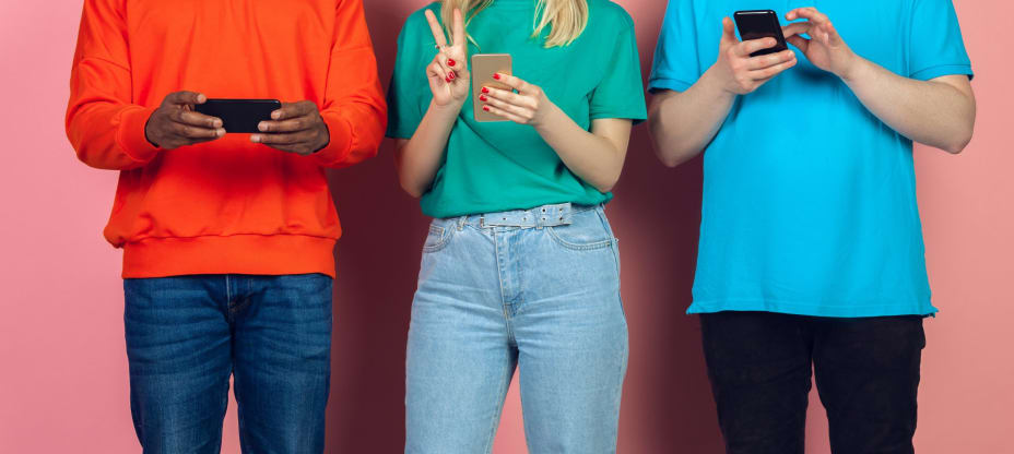 young people in colourful t-shirts using mobile phones