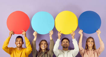 Happy smiling young people holding up colourful speech bubbles