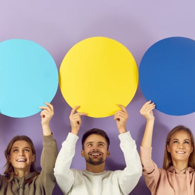 Happy smiling young people holding up colourful speech bubbles