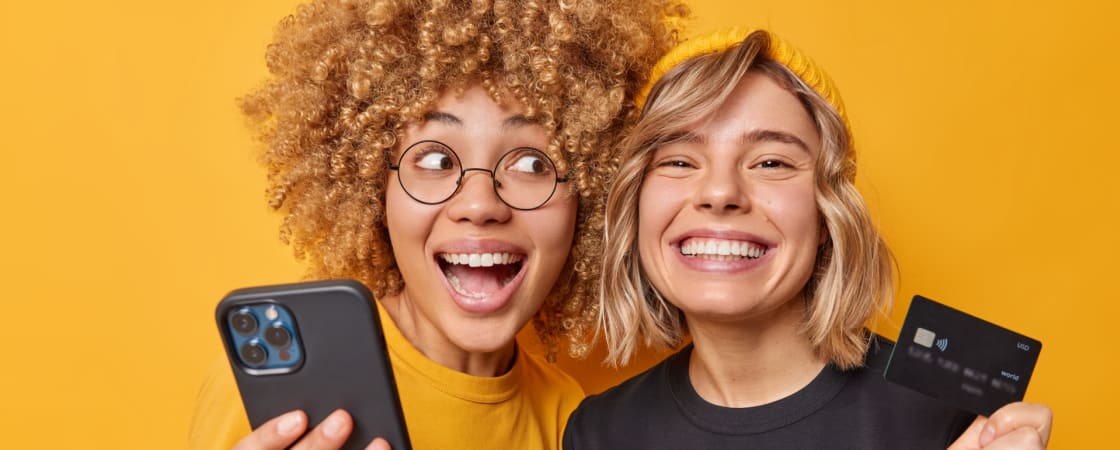 two young girls holding a telephone and a credit card