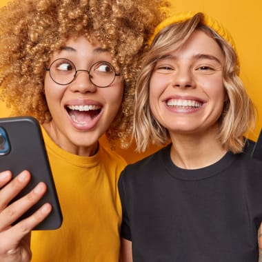 two young girls holding a telephone and a credit card