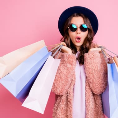 woman with shopping bags on a pink background