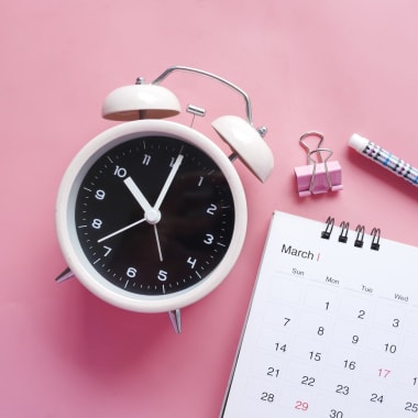 Clock and calendar on the pink desk