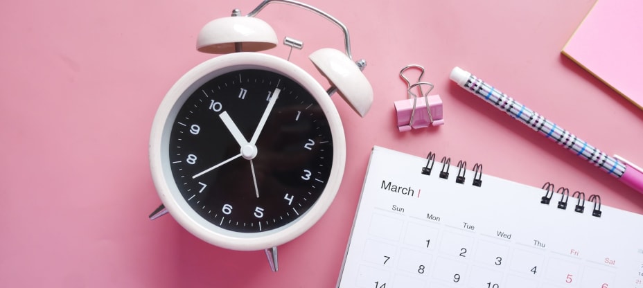 Clock and calendar on the pink desk
