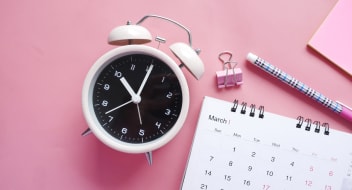 Clock and calendar on the pink desk
